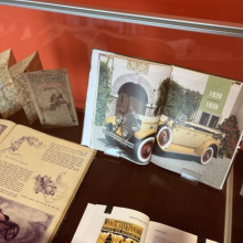 In the display case: a map and books depicting cars from 1920-1930.