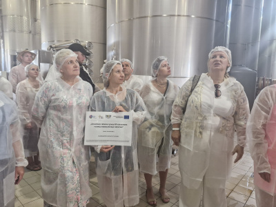 uczestnicy wyjazdu w zakładzie przetwórczym, w strojach ochronnych i czepkach