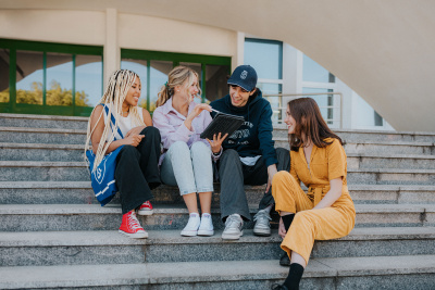 Uśmiechnięci studenci siedzący na schodach