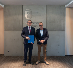 Prof. Przemysław Borkowski i Rektor UG, prof. Piotr Stepnowski, na tle ściany z logo UG