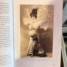 Karta z czasopisma: Elegancka kuracjuszka trzymająca otwartą parasolkę. Obok niej siedzi pies. 