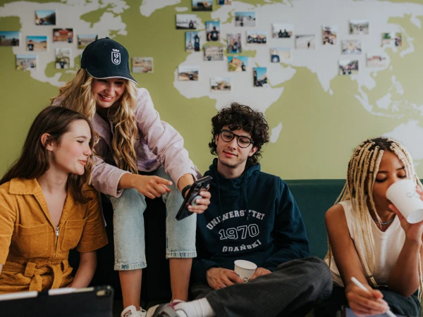 Studenci na tle ściany z mapą świata