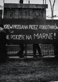 Zdjęcie czarno-białe - ilustracja konferencji "Za chleb i wolność..." Parkan z transparentem "Krew przelana przez robotników nie pójdzie na marne"