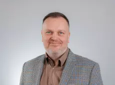 zdjęcie przedstawiające Mariusza Grinholca, w garniturze