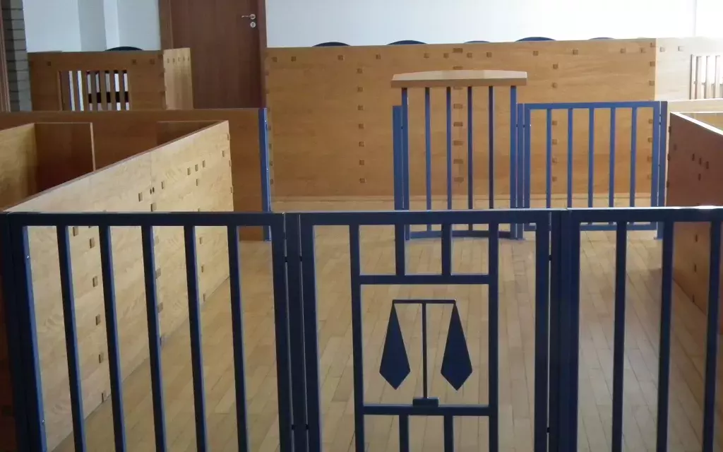 widok sali rozpraw w kierunku ławy sędziowskiej. pokazane wyposażenie i wystrój mający na celu odwzorowanie prawdziwej sali rozpraw sądowych