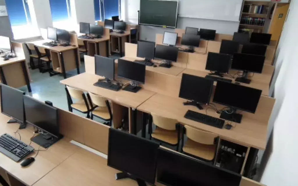widok jednej z przykładowych pracowni komputerowych pokazujący układ krzeseł, ławek, oraz zestawy komputerowe