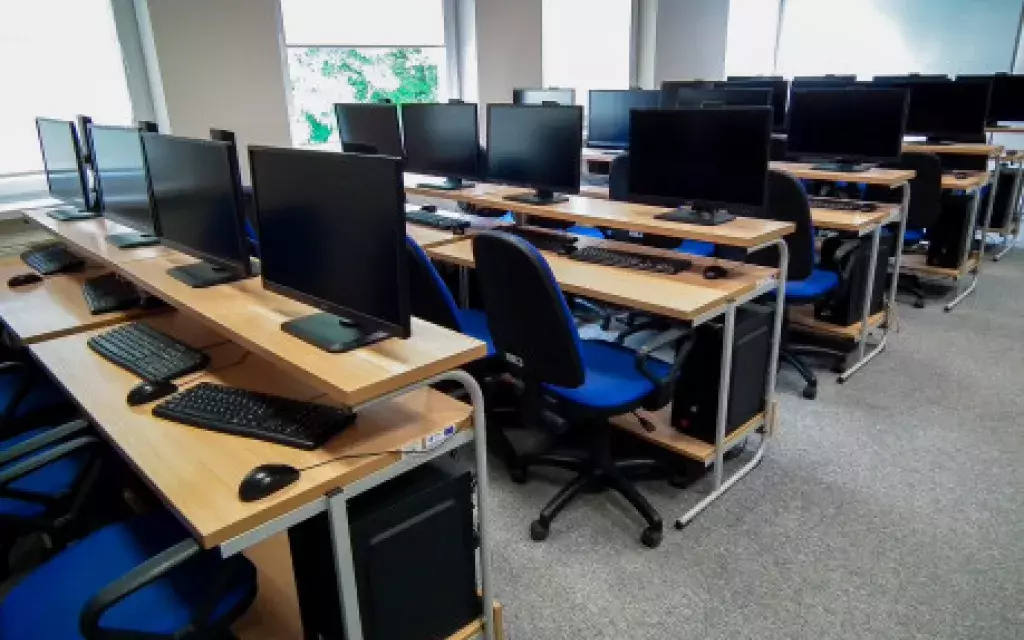 widok jednej z przykładowych pracowni komputerowych pokazujący układ krzeseł, ławek, oraz zestawy komputerowe