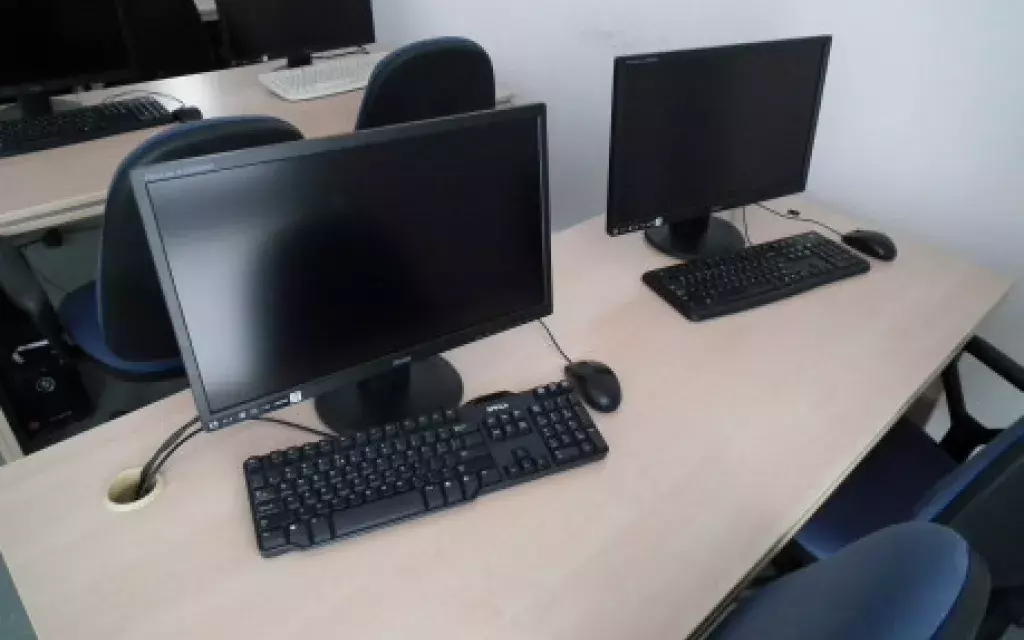 przykład zestawu komputerowego na biurku w jednej z pracowni komputerowych : komputer stacjonarny, monitor