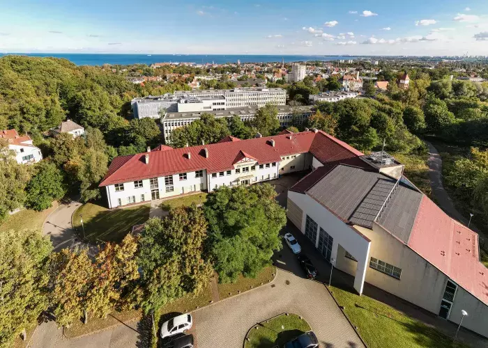 widok z drona na którym widać cały obiekt Centrum Dydaktyczno-Konferencyjnego, w tle centrum Sopotu, a dalekim planie widać morze Bałtyckie