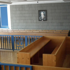 widok jednej z sal rozpraw pokazujący bramki oraz ławę przysięgłych