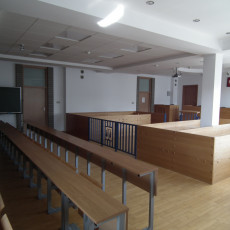 widok jednej z sal rozpraw z tyłu w stronę ławy sędziowskiej