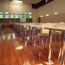 widok auli z boku  pokazujący układ stołów, krzeseł, elegancką, drewnianą podłogę
