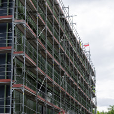 Zdjęcie przedstawia Centrum Sportowe UG z zewnątrz, zbliżenie na bok z rusztowaniem.