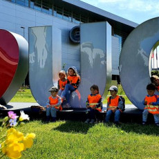 Przedszkolaki poznają okolice UG, na zdjęciu grupa dzieci siedzi na napisie "I love UG"